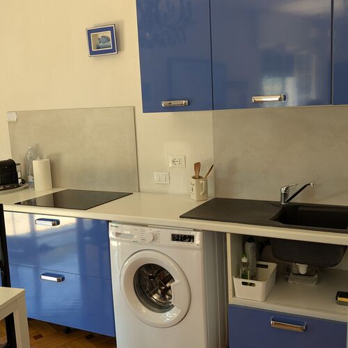 Cucina attrezzata con piano cottura e lavatrice